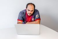 Foto: Mann sitzt hinter Laptop