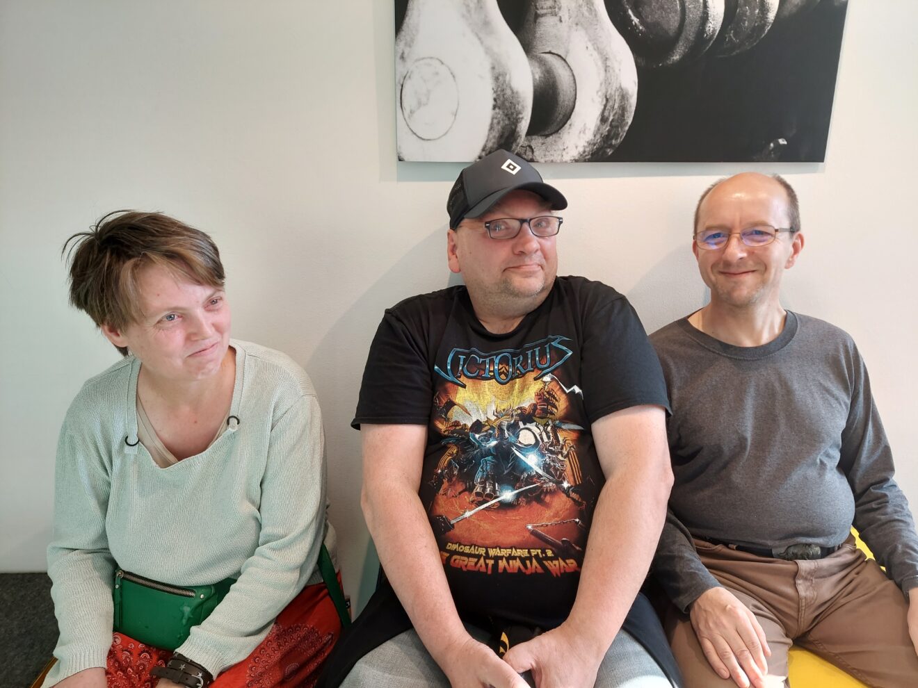 Foto: Drei Personen sitzen nebeneinander