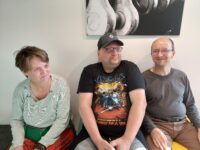 Foto: Drei Personen sitzen nebeneinander