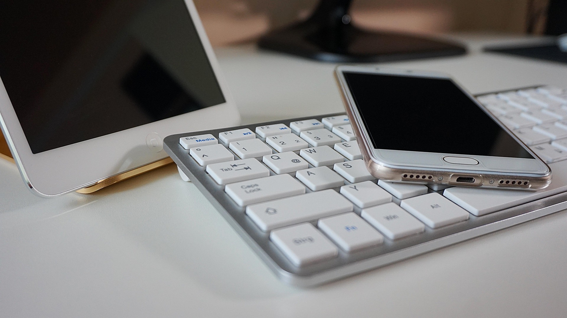 Ausschnitt von einer Tastatur, darauf liegt ein Smartphone